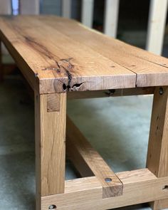 a wooden bench sitting on top of a cement floor