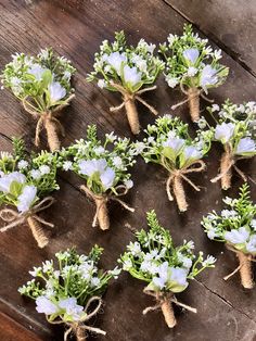 small white flowers tied together with twine on a wooden table in the shape of hearts