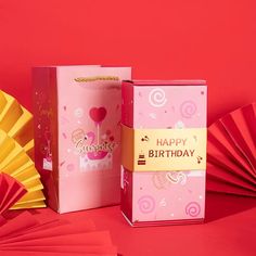 a pink birthday card and fan on a red background