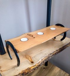 a wooden table with three white plates on it and two black poles in the background