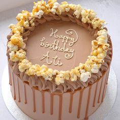 a birthday cake with chocolate frosting and popcorn decorations