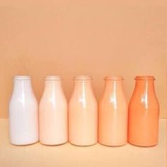 five different colored milk bottles lined up in a row