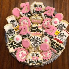 decorated cookies in the shape of numbers on a glass plate with pink and white icing