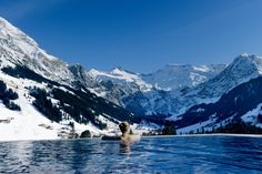 a person sitting in the middle of a pool surrounded by mountains