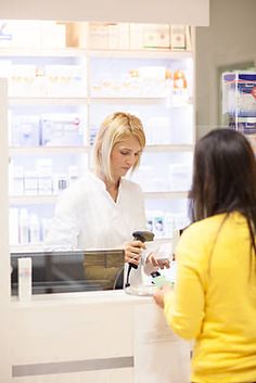 two women standing at a counter in a pharmacy