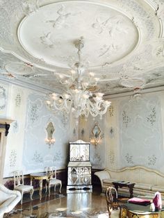 an ornately decorated room with chandelier and chairs