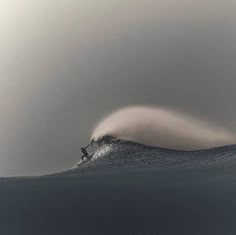 a man riding a wave on top of a surfboard in the middle of the ocean