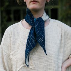 a woman wearing a blue and white polka dot neck tie with her hands on her hips