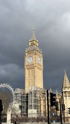 the big ben clock tower towering over the city of london, england under a cloudy sky