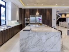 a large kitchen with marble counter tops and wooden cabinets