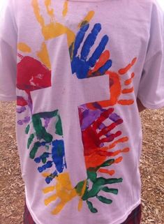 a young boy wearing a t - shirt with hand prints on it