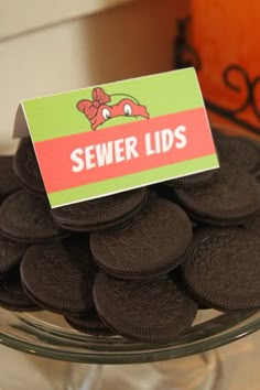 a bowl filled with chocolate cookies sitting on top of a table next to a sign