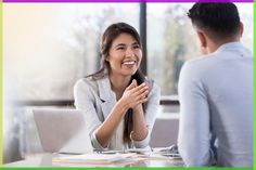 two people sitting at a table with laptops and papers in front of them, the woman is clapping