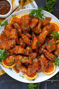 a white plate topped with orange slices and chicken wings