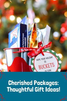 a bucket filled with gift items sitting in front of a christmas tree