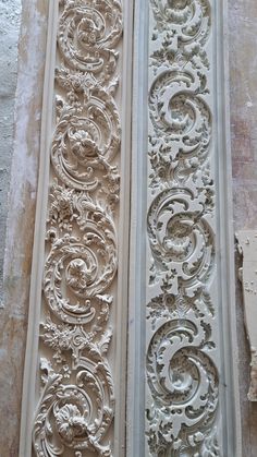 two decorative plaster molds on the side of a building