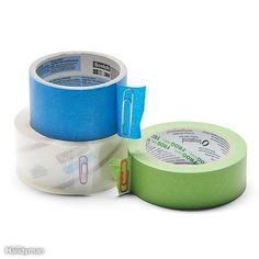 two rolls of tape sitting next to each other on a white surface, one blue and the other green