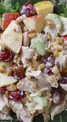 a salad with apples, grapes and nuts in it