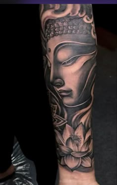 a person with a buddha tattoo on their arm and leg is shown in black and white