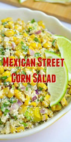 mexican street corn salad in a white bowl with limes on the side and text overlay