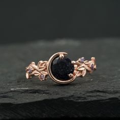 a black diamond ring sitting on top of a rock