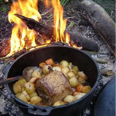 roasting meat and potatoes over an open fire