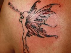 the back of a woman's shoulder with a fairy tattoo on her left side