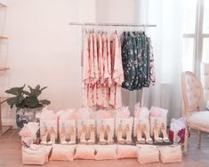 several pairs of shoes are on display in front of a rack full of dresses and other items