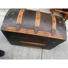 an old trunk is sitting on the sidewalk