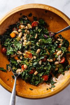 a wooden bowl filled with beans and greens