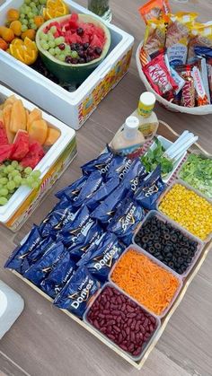 several trays filled with different types of fruits and vegetables on top of a wooden table