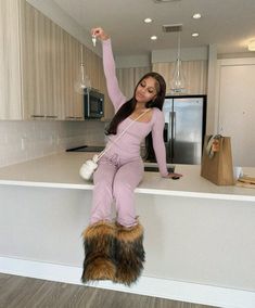 a woman standing on top of a counter with her arms in the air and legs up