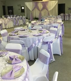 the tables are set up with purple and white linens