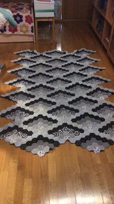 the floor is covered in black and white lacy doily, which has been placed on top of a hard wood floor