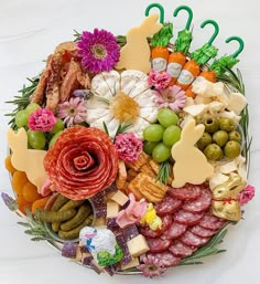 a platter filled with lots of different types of meats and cheeses on top of each other