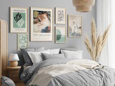 a bedroom with gray walls and pictures on the wall above the bed, along with a wicker basket