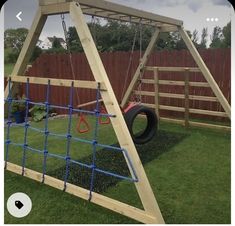 a wooden swing set in the grass