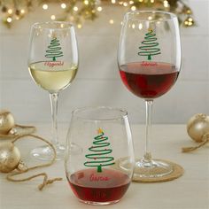 two wine glasses filled with red and white wine next to a christmas ornament