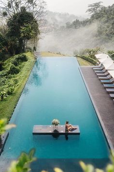 a woman sitting on the edge of a swimming pool