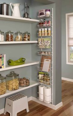 an organized pantry with white shelves filled with food