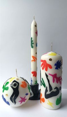 two candles with hand painted designs next to each other