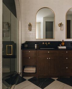 a bathroom with two sinks and mirrors in it