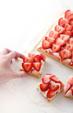 someone is cutting up some dessert with strawberries on it