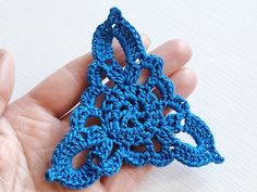 a crocheted object being held in someone's hand