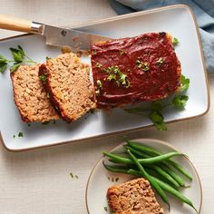 meatloaf and green beans on a plate with a knife