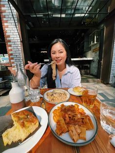 a woman sitting at a table with plates of food