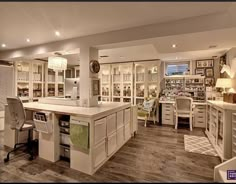 a large kitchen with lots of white cabinets and counter top space in front of it