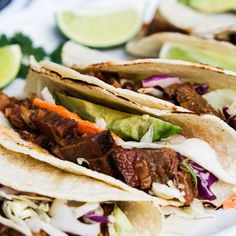 three tacos with meat and vegetables on a plate