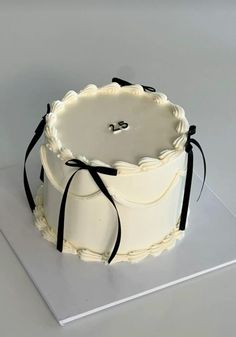 a white cake with black ribbon around it