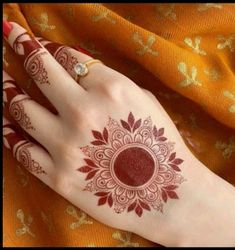 a woman's hand with henna on it and a diamond in the middle